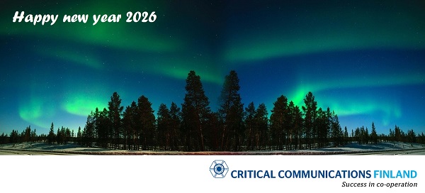 Happy New year 2026 by Critical Communications Finland #SuccessInCooperation Northern lights in behind a peninsula of pine trees